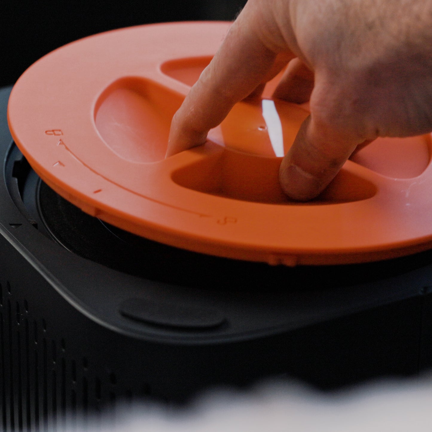 Hand removing the air filter cover on a Wyze Air Purifier.